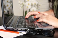 电子电工人妇女桌子笔记本电脑笔记本电脑工作打字书写窗户电脑眼镜写微软作家