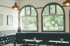咖啡馆内部采用黑色转角沙发玻璃窗木制的桌子和吊灯