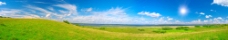 蓝天白云下的草原春天全景图片