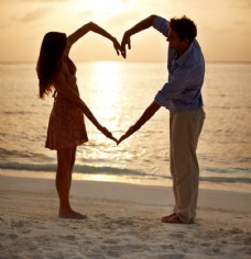 沙滩上做爱心手势的夫妻图片