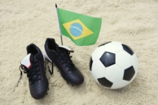 沙滩上的球鞋与足球图片
