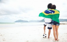 世界旗帜沙滩上披着世界杯旗帜的情侣图片